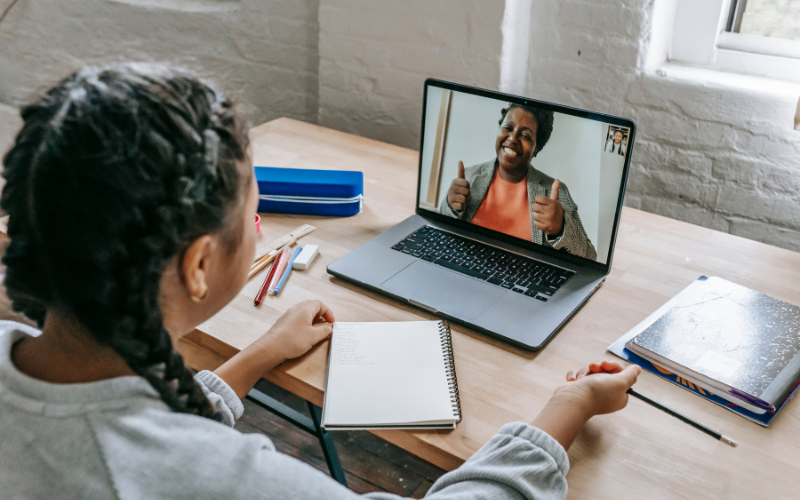 A child on zoom talking with a teacher